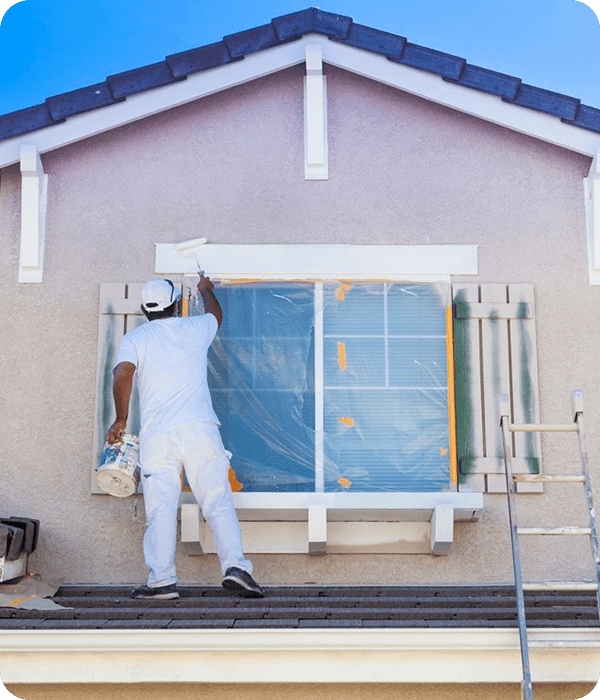 A man painting the outside of a house.