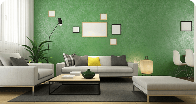 A living room with green walls and white furniture.